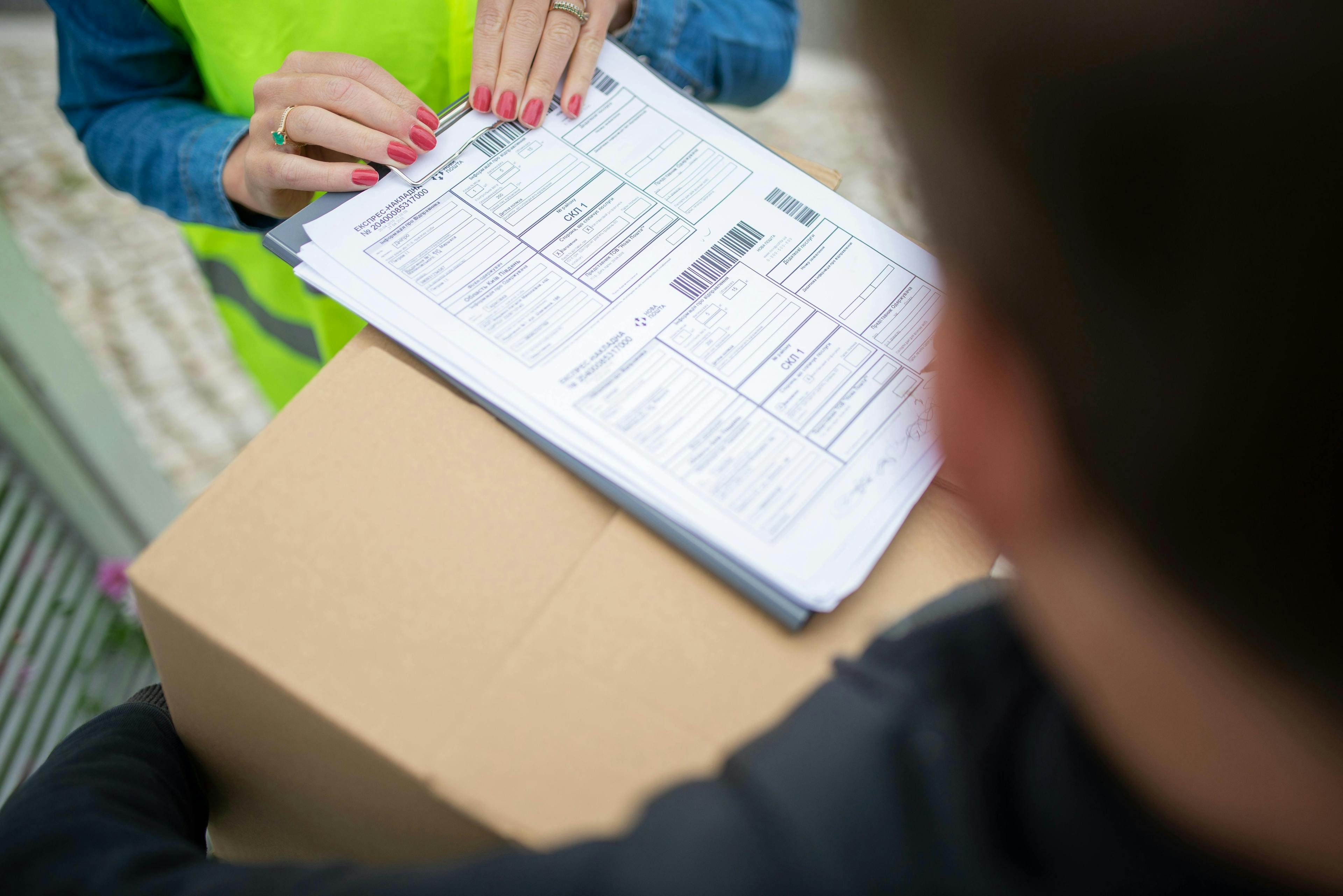 woman holding papers above a box