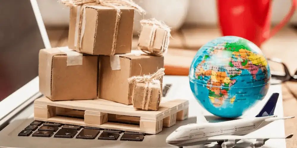 boxes, globe and a miniature plane on a computer placed on a desk