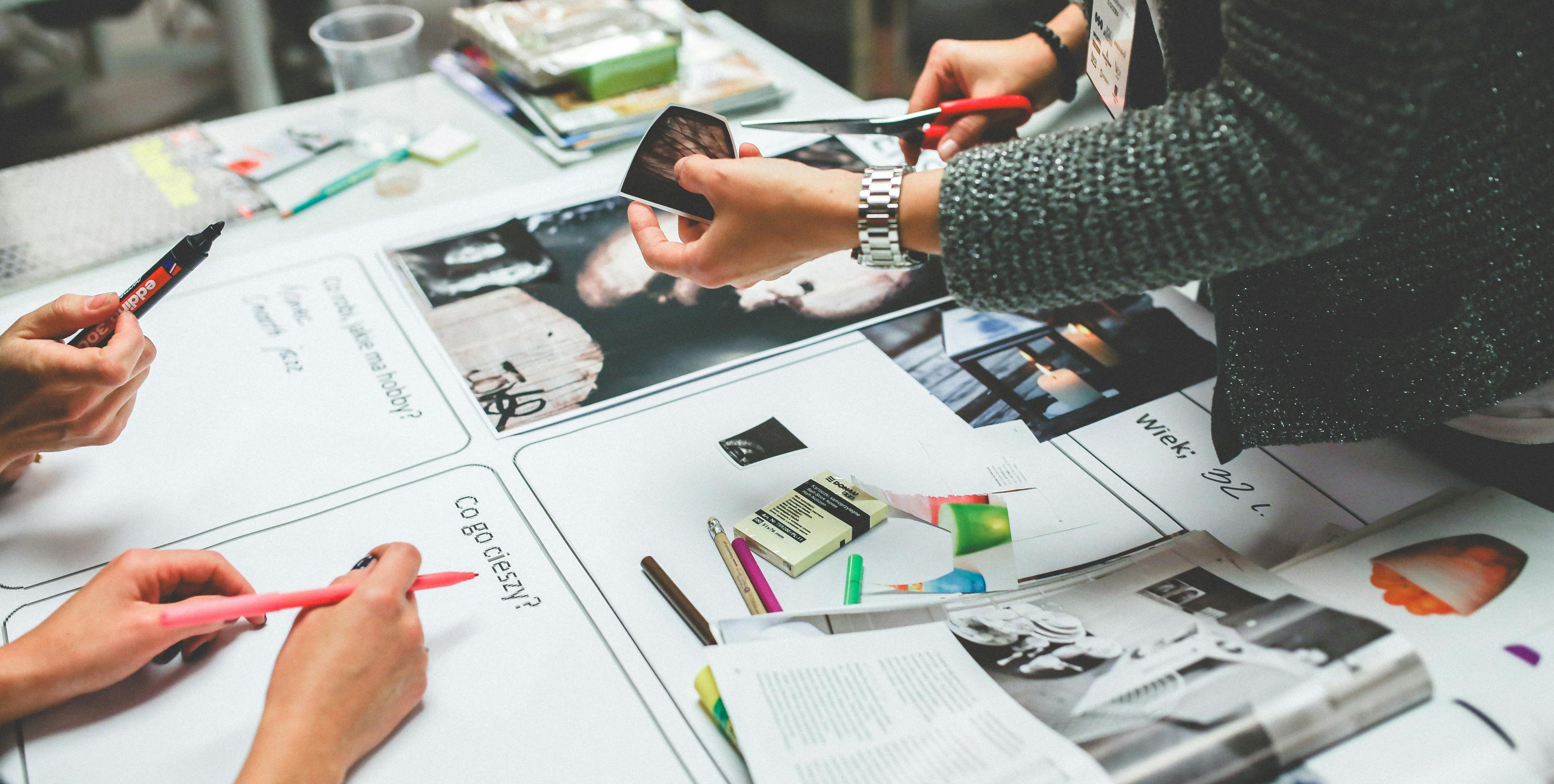 Magazines, papers and pens lying on the table. woman cutting photo