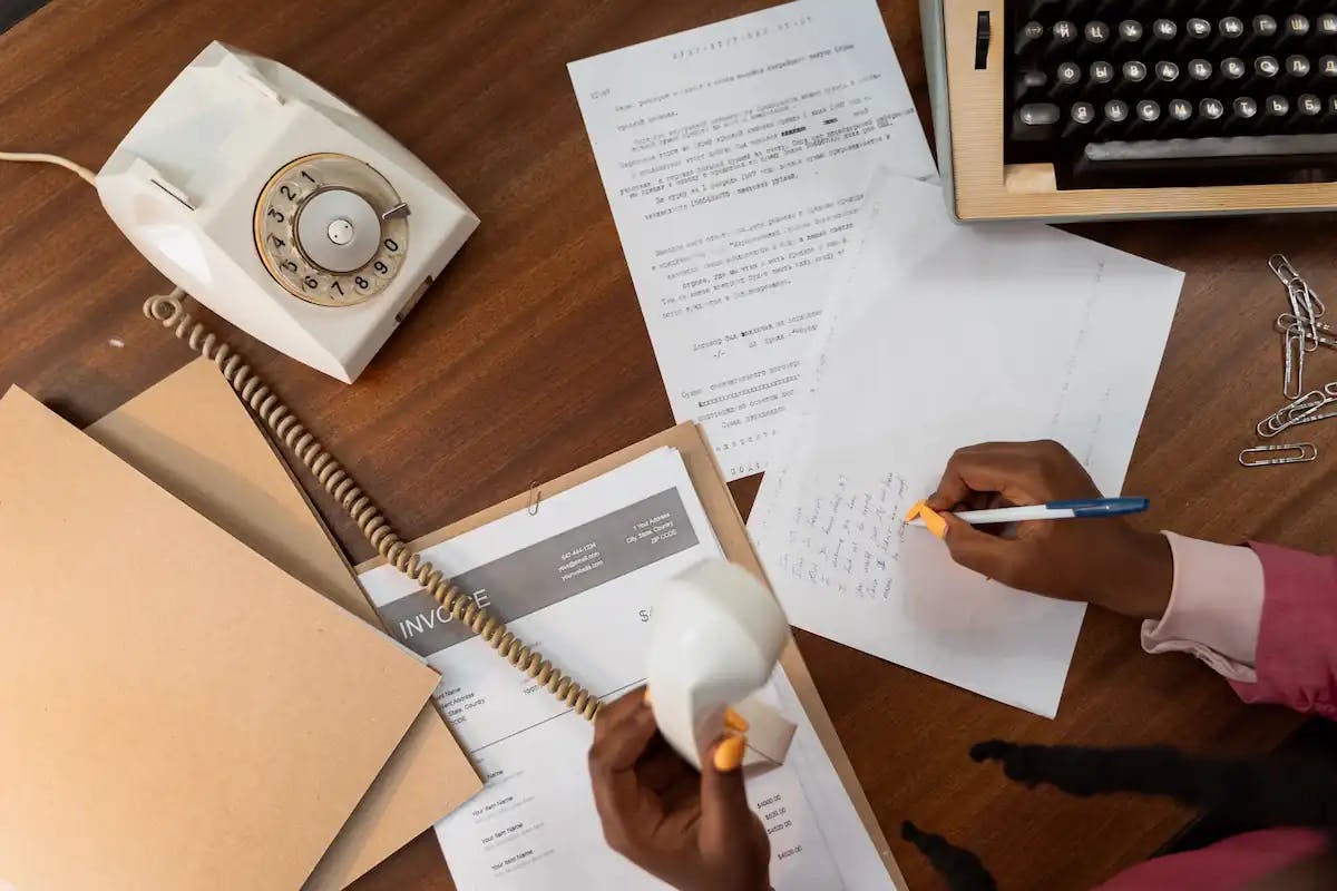 Telefon ahizesini tutan ve kağıda not alan bir kişi