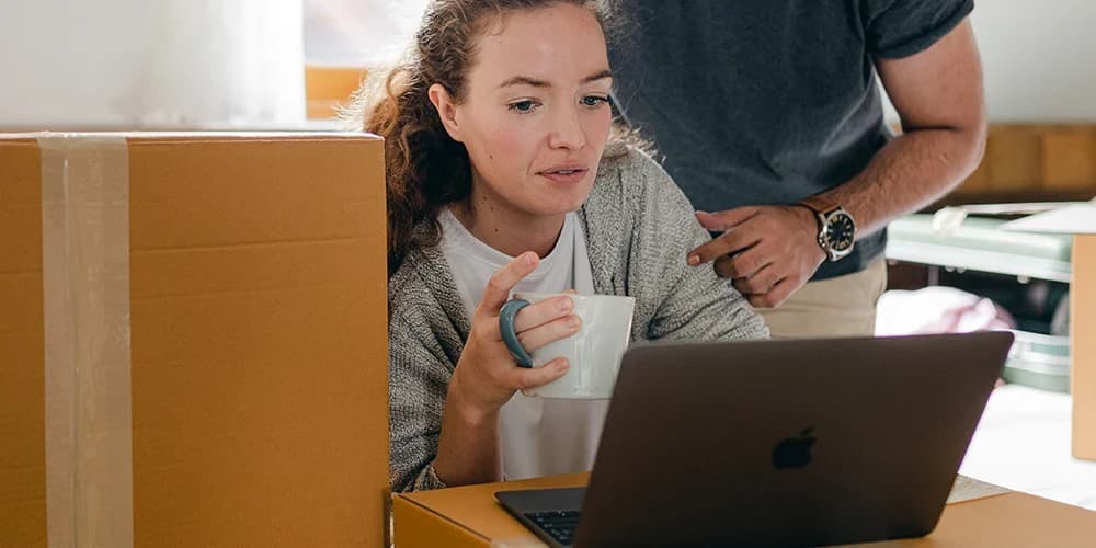 Kutular arasında laptopta çalışan kadın