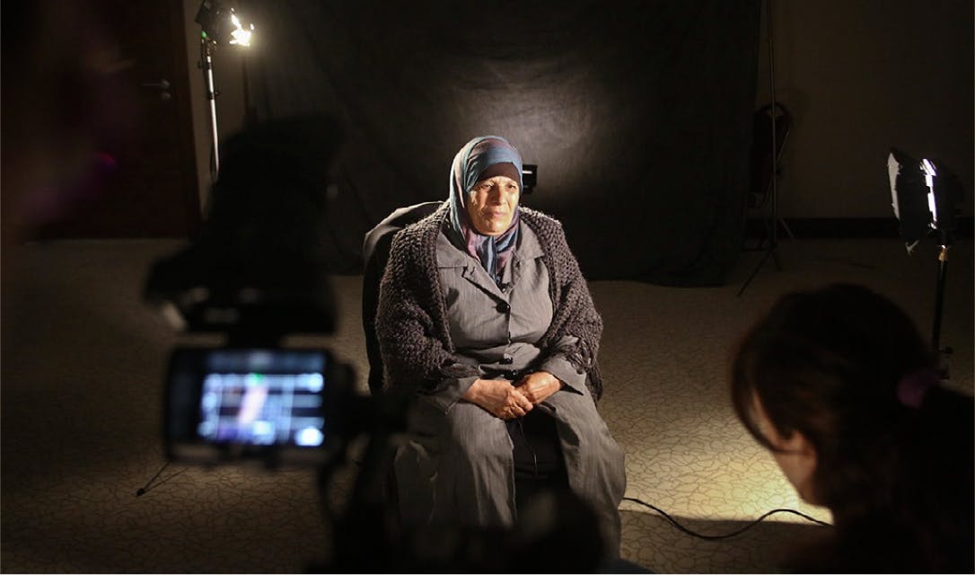 Old woman, on set, being recorded for the documentary.