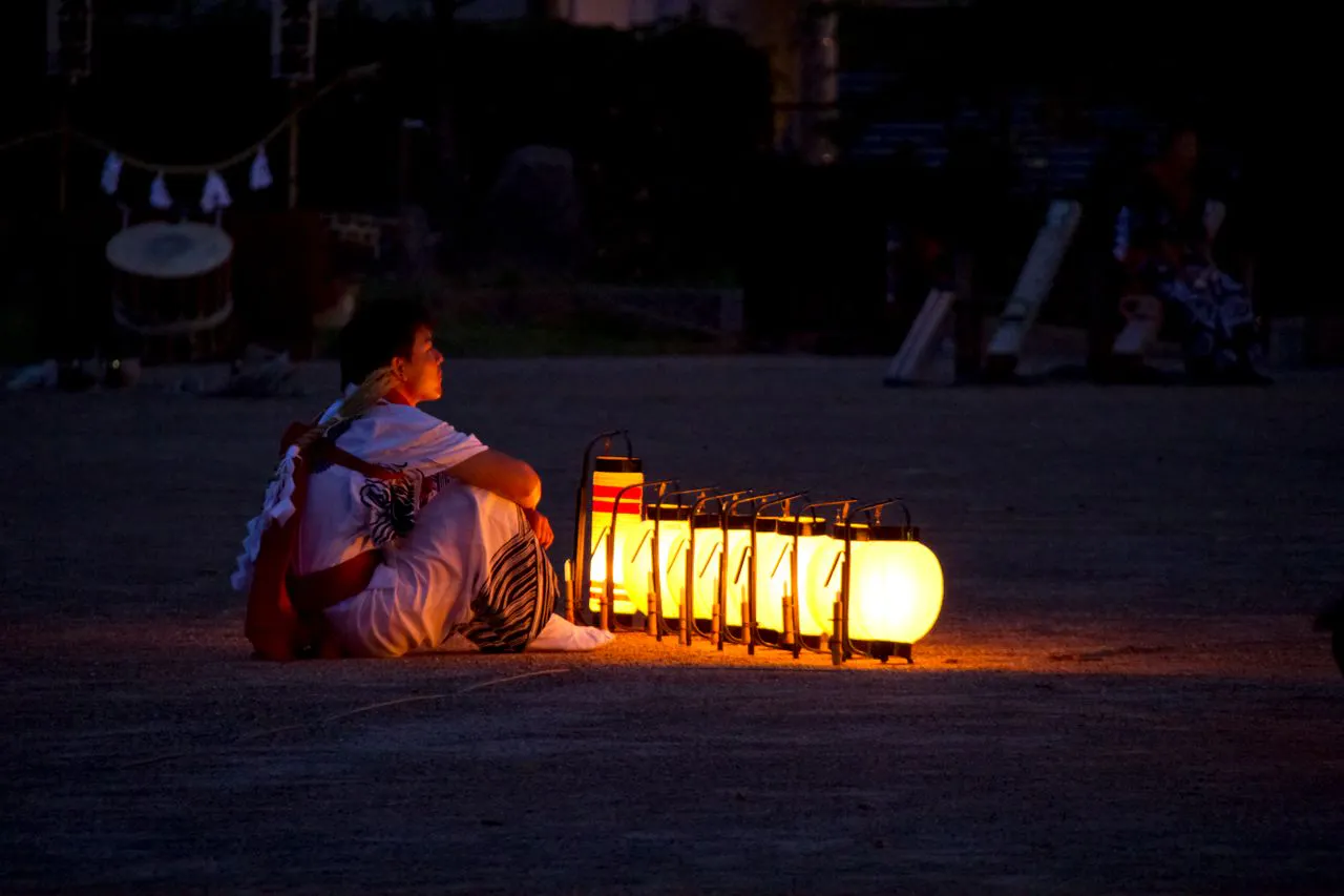 Man sitting in front of Obon lanterns
