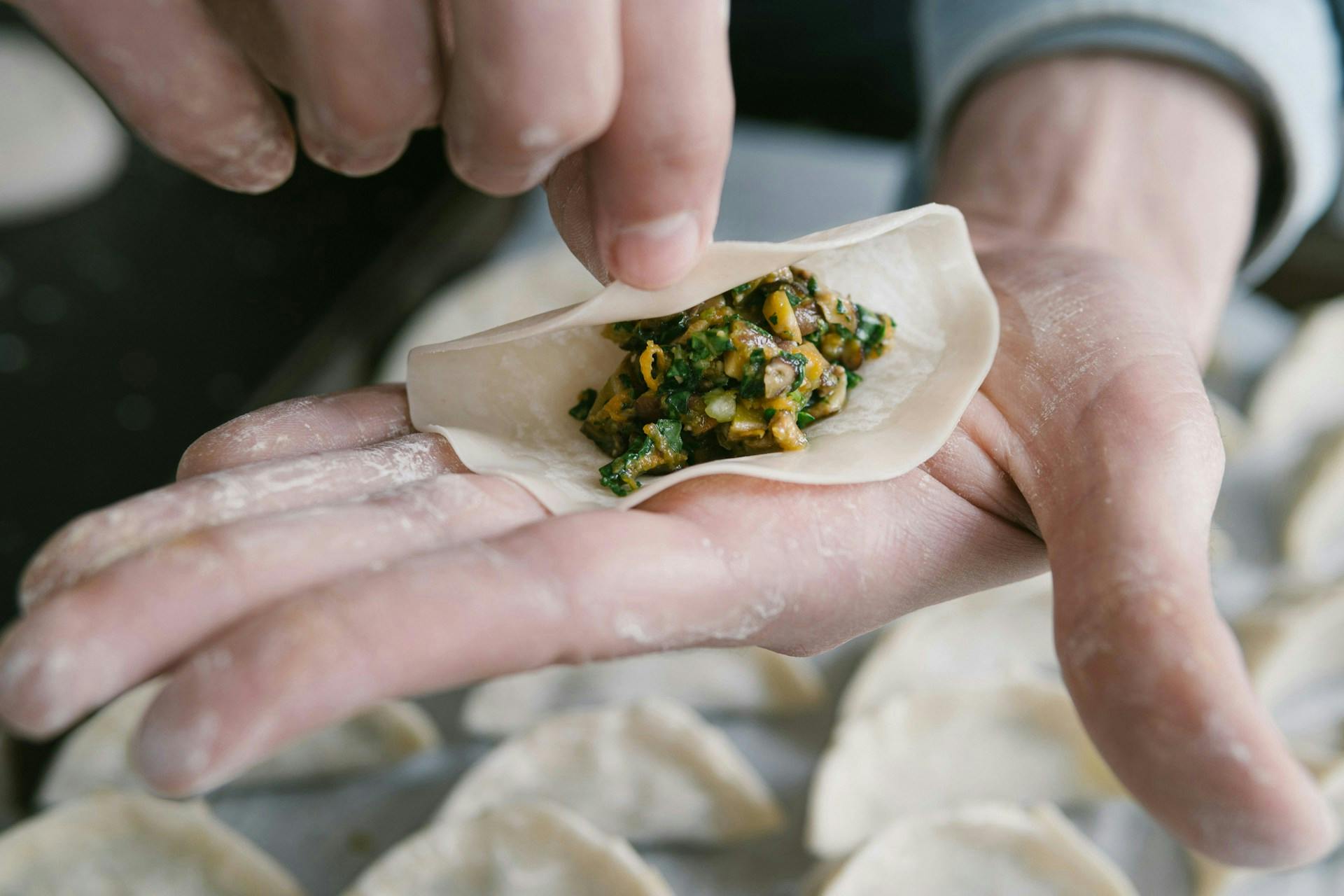 Someone wrapping a gyoza