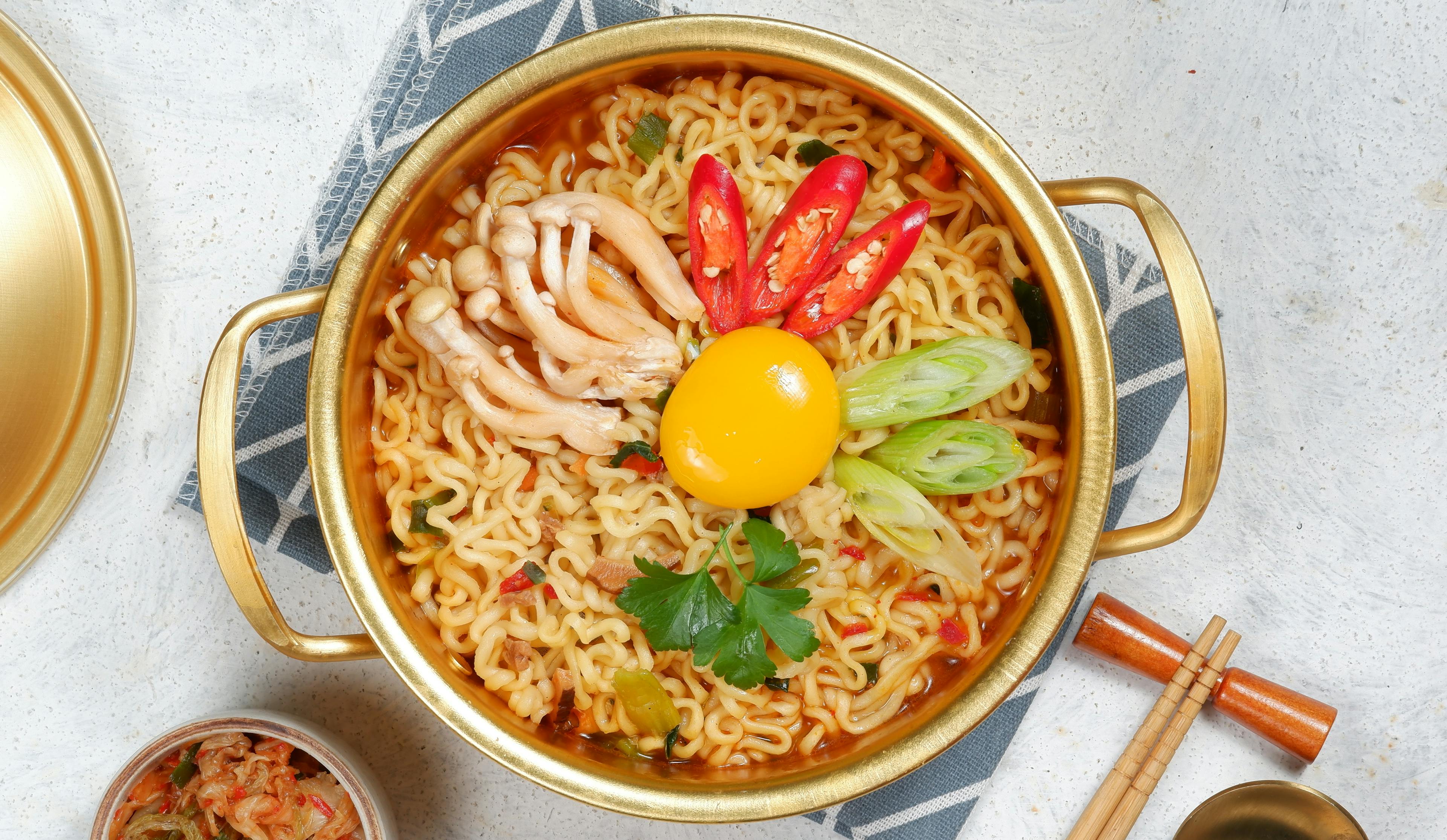 korean instant noodle serves in a traditional korean golden pot