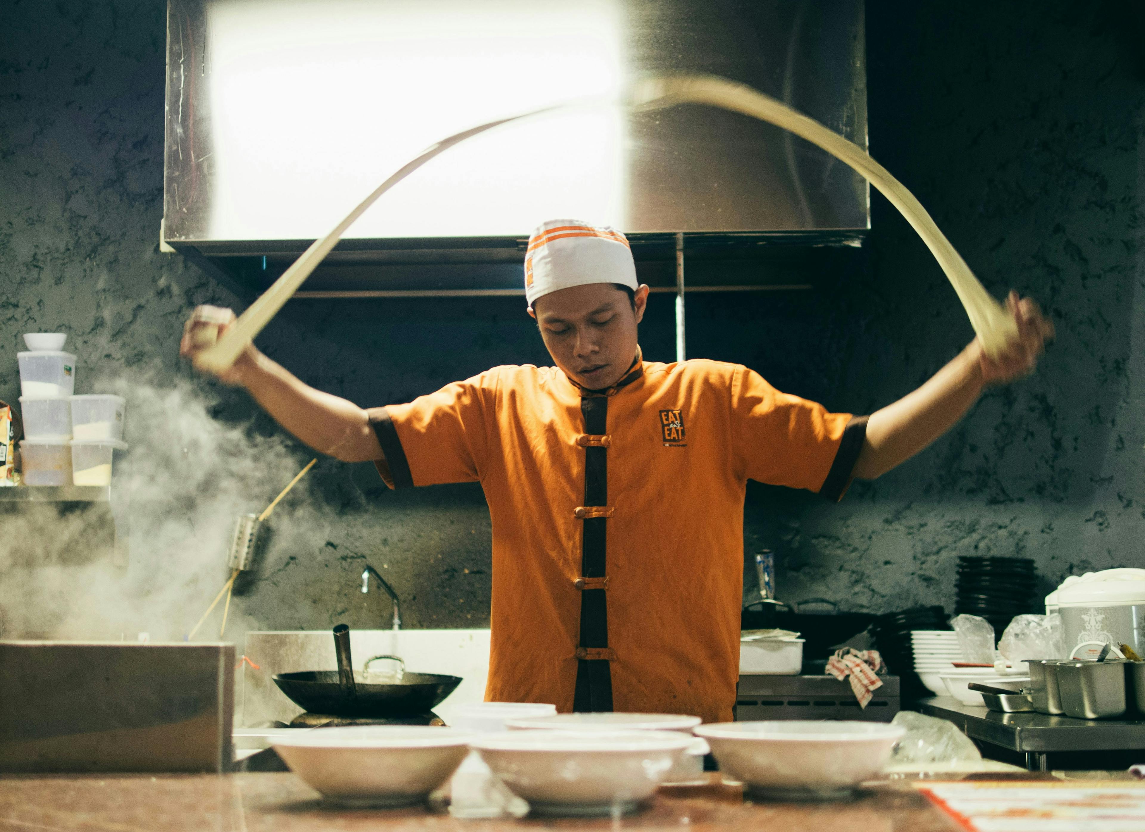 a chef preparing hand-pulled noodles