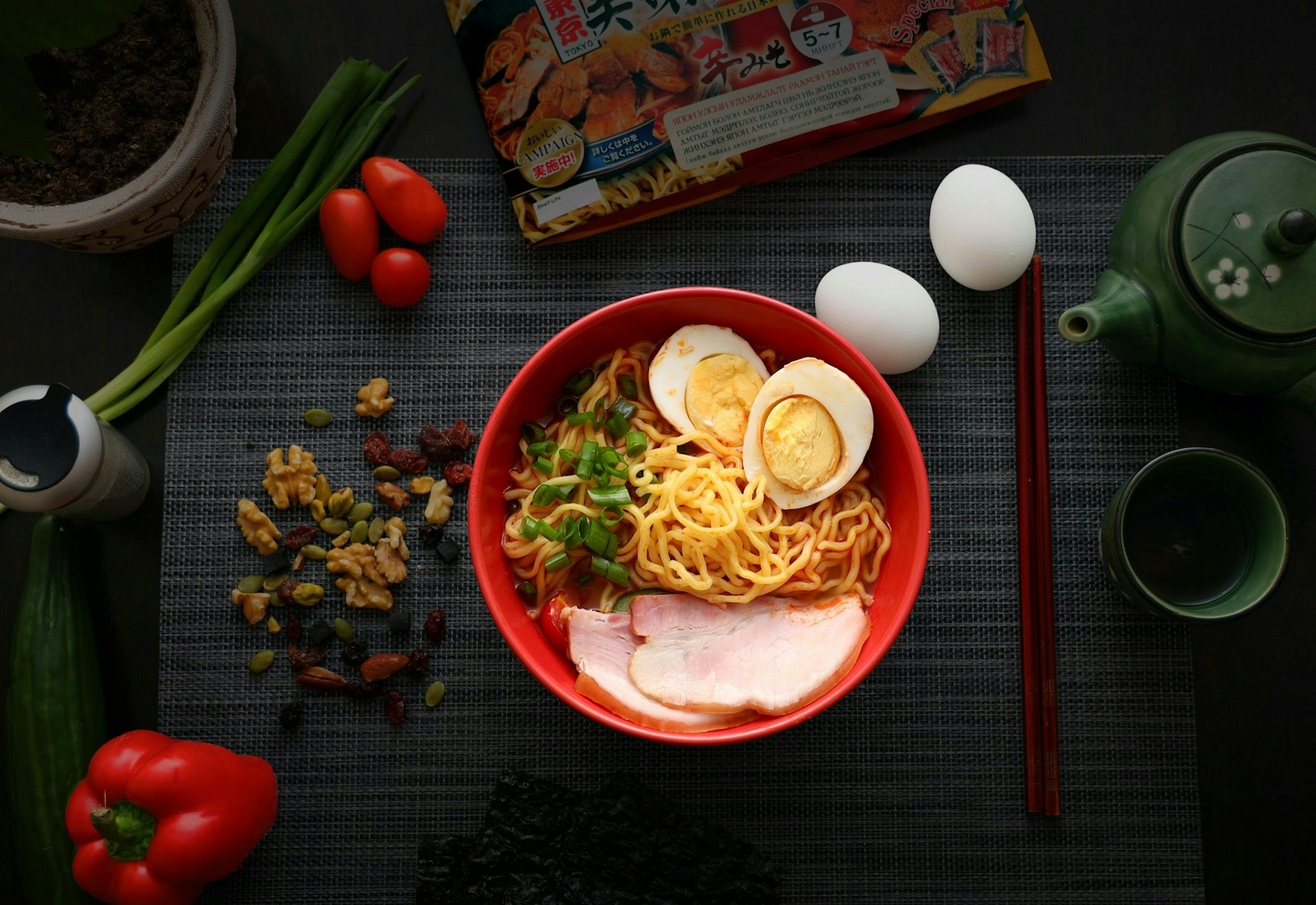 a bowl of instant noodles with egg, meat and seasoning