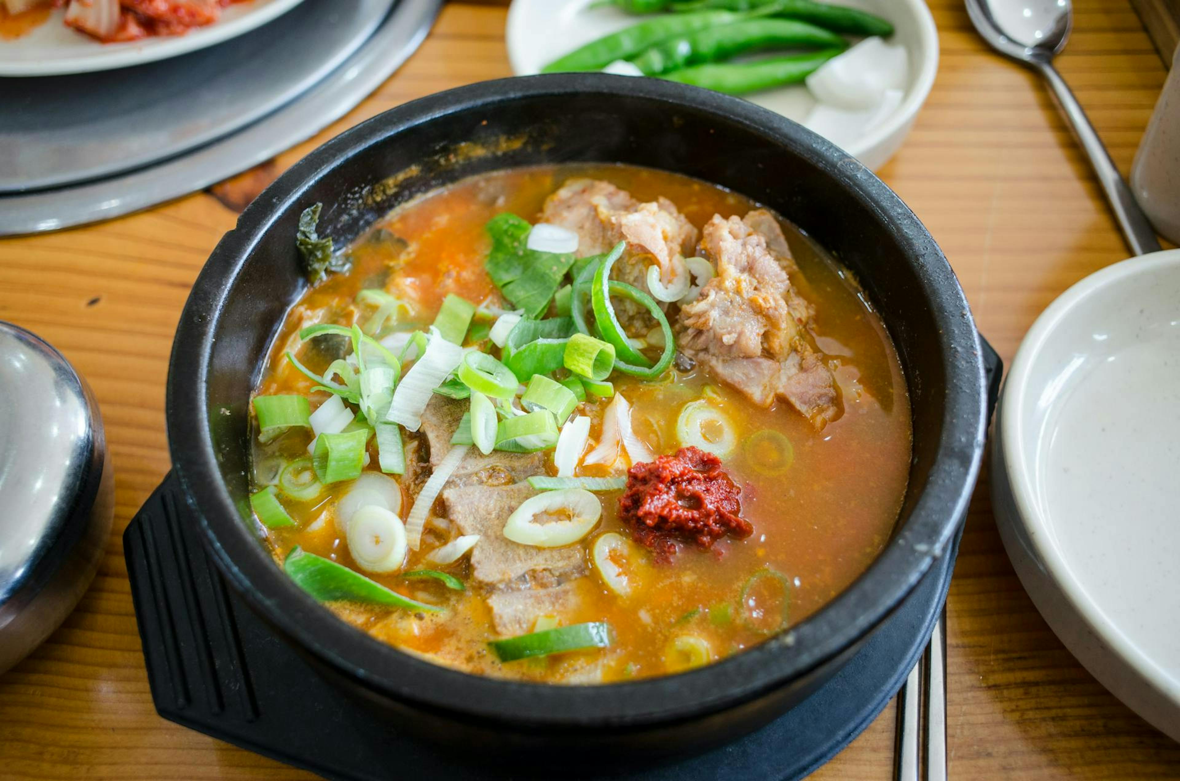 A hot pot with vegetables, meat and soup