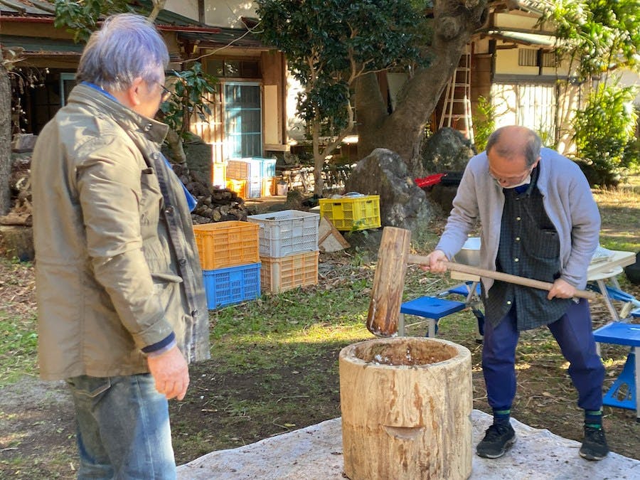 Two men making mochi in the traditional way