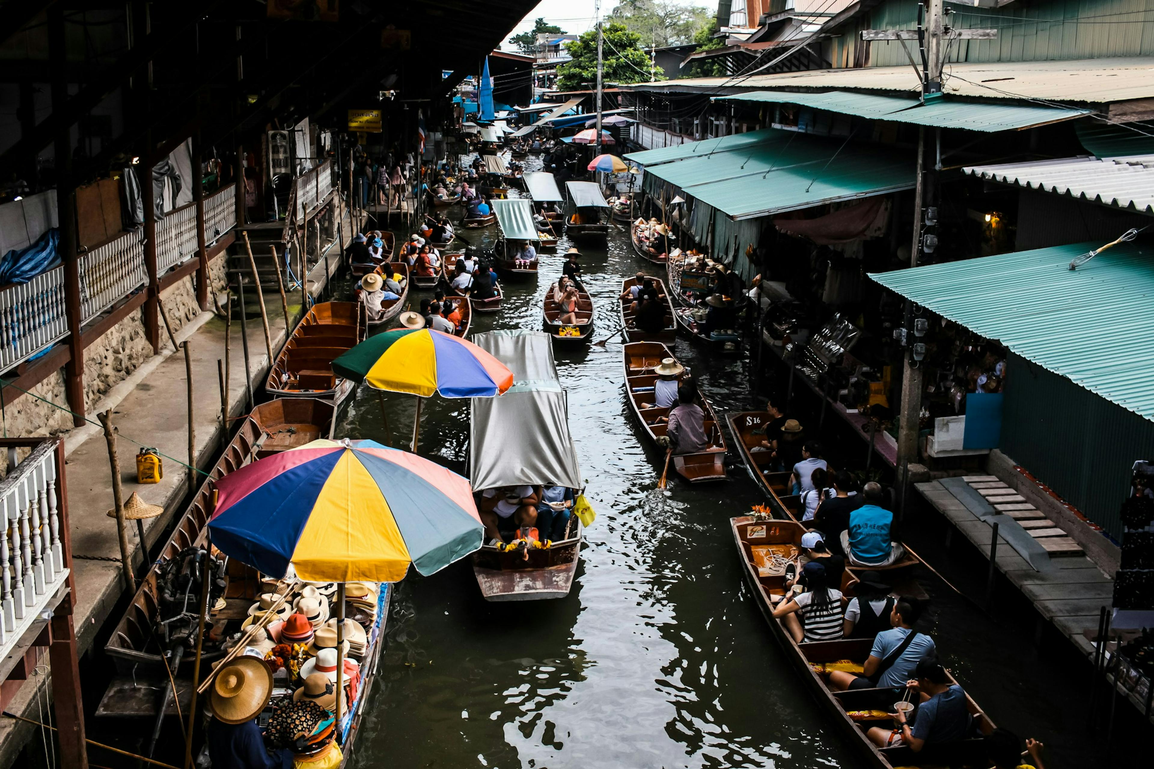 boats passing through a market in Bangkok Thailand