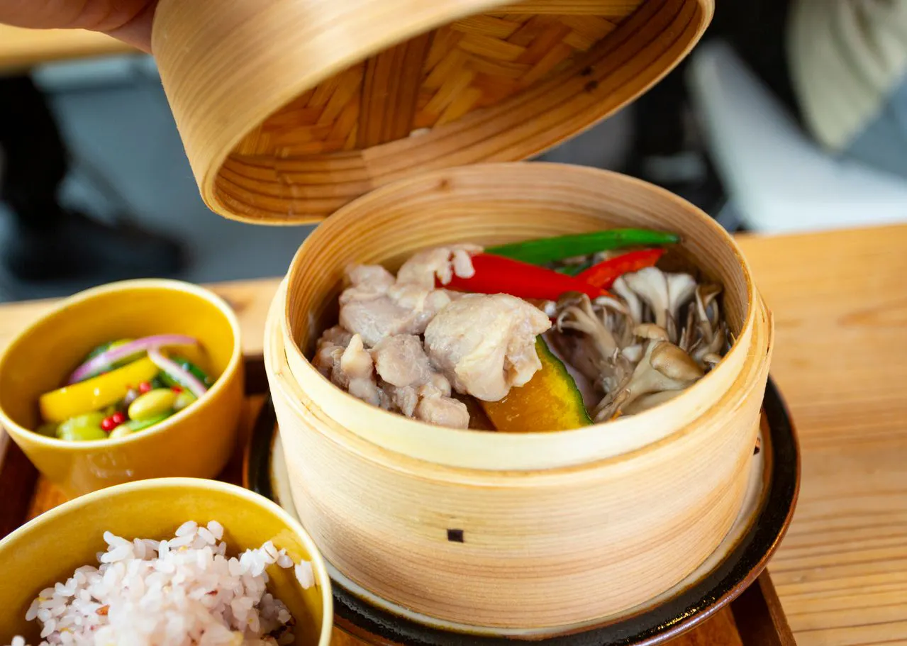 Mushrooms steaming in bamboo steamer with other ingredients