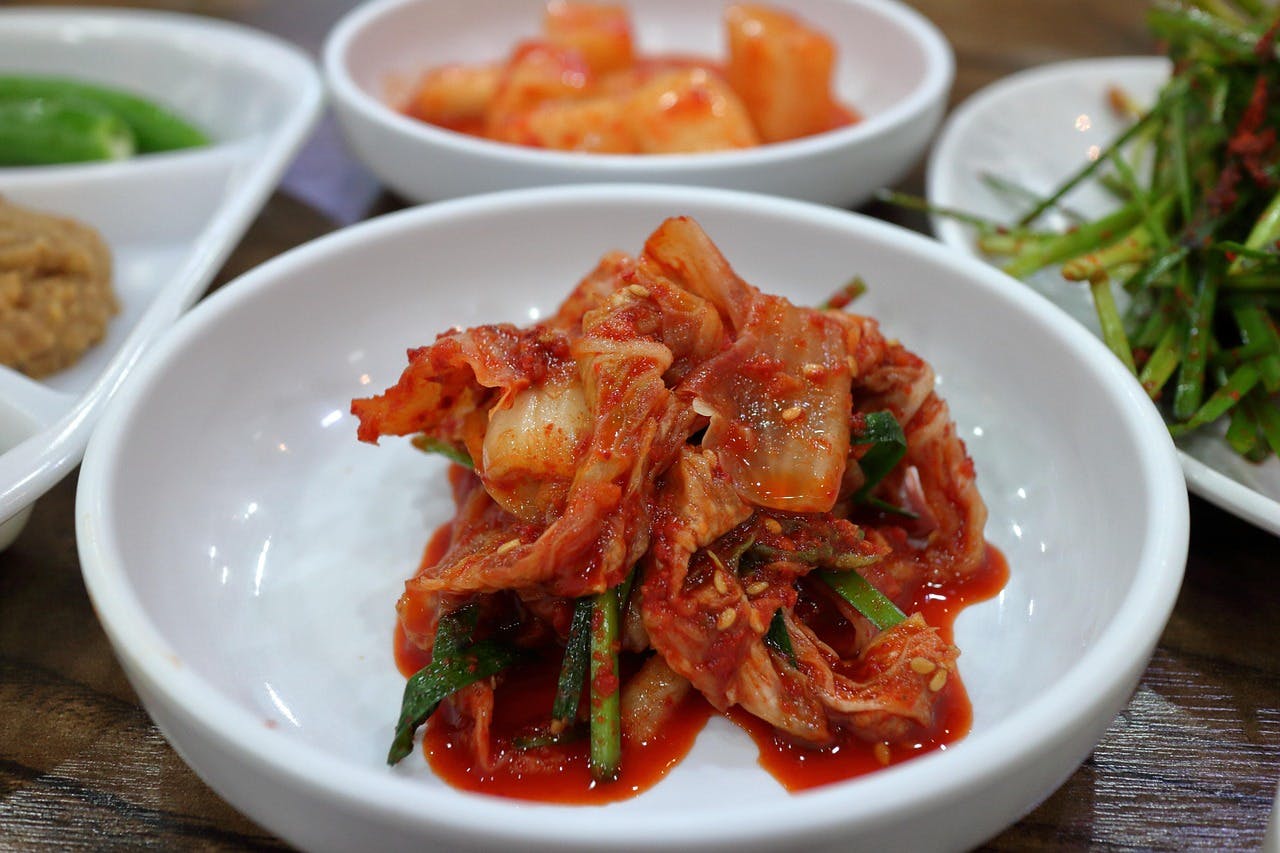 A bowl of kimchi and other side dishes