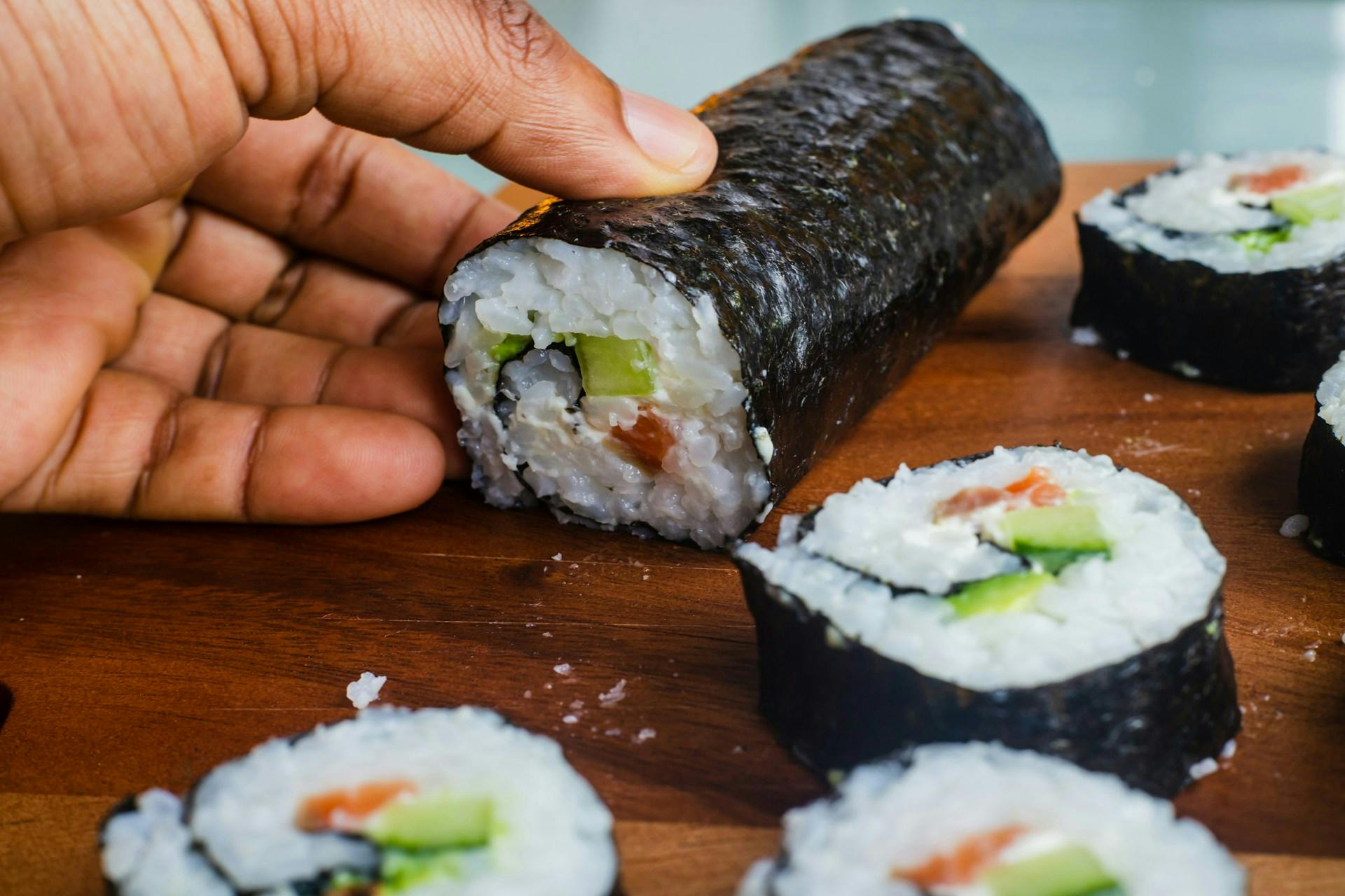 someone picking up a sushi roll