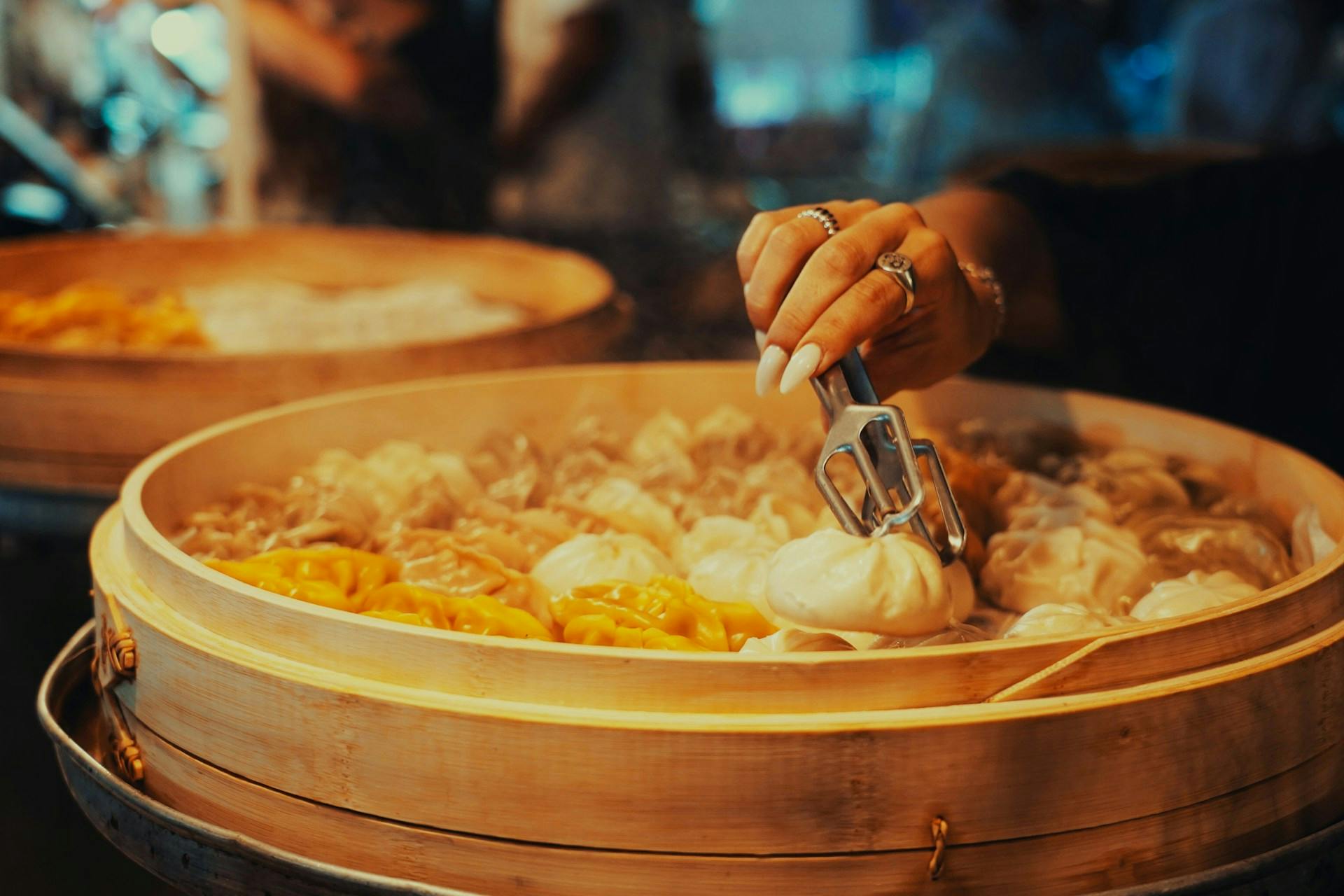 Someone cooking using a bamboo steamer