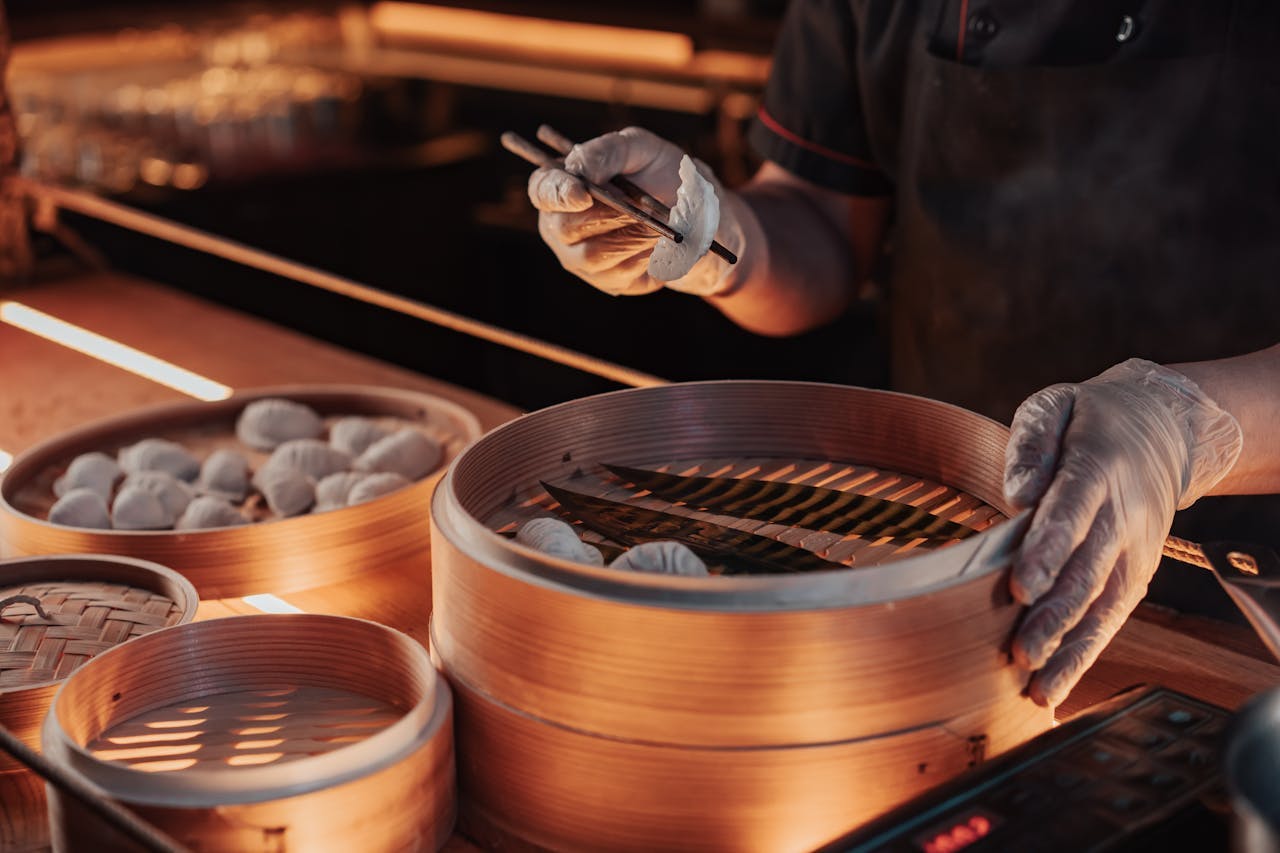 A chef preparing a bamboo steamer