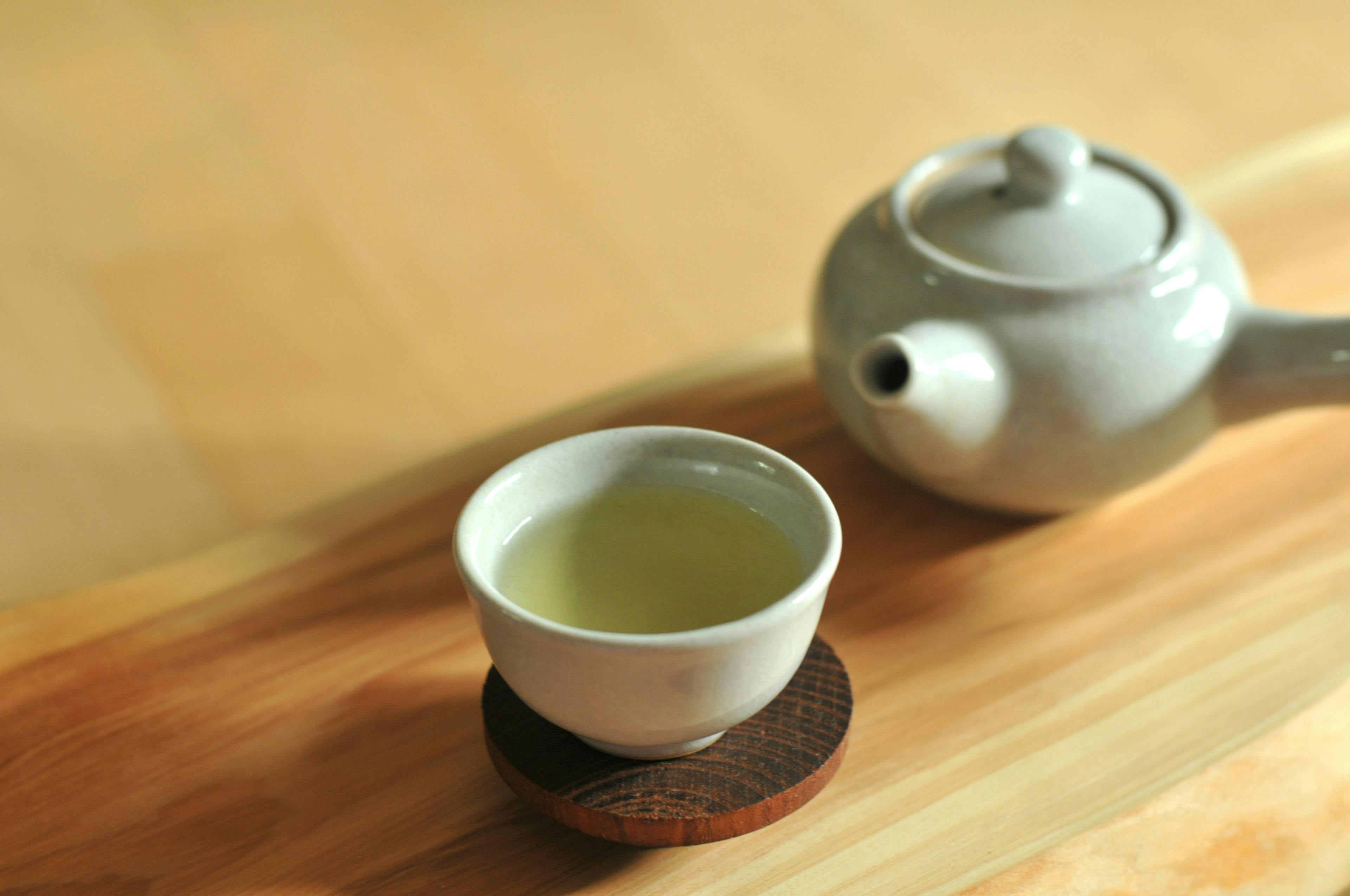 Cup of green tea and pot