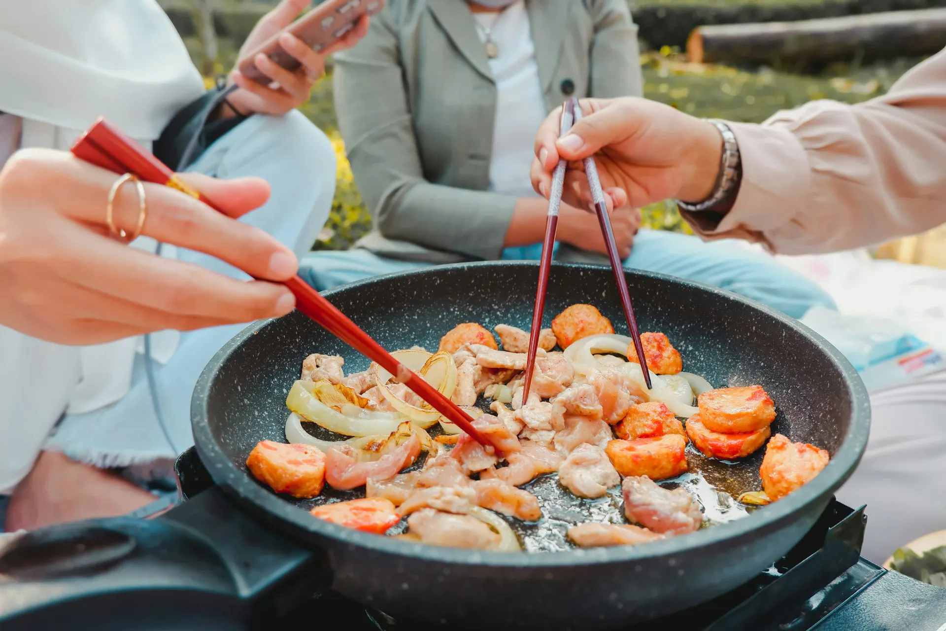 People using chopsticks to pick stir fried food