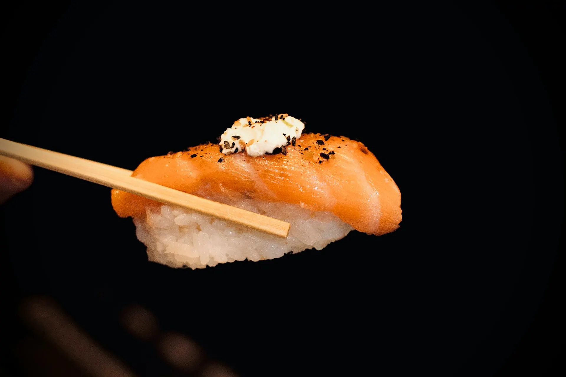 Salmon Nigiri held with chopsticks