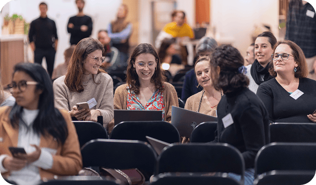 Groupe de participants assis, certains utilisant des ordinateurs, pendant une session