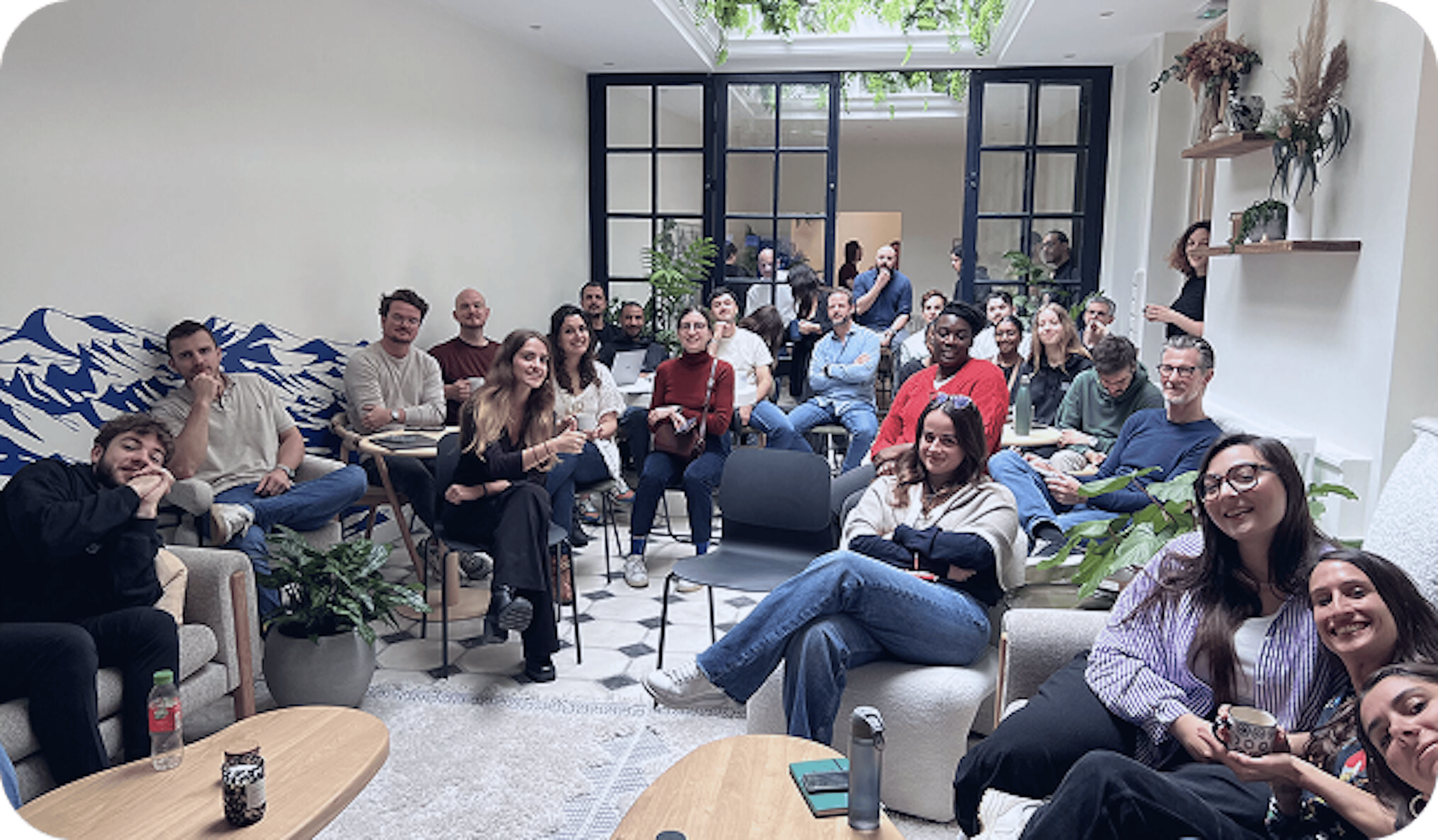 Groupe de participants assis et souriants dans un espace convivial