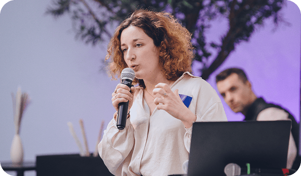 Intervenante tenant un micro et parlant devant un public