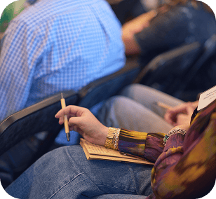 Participant prenant des notes assis dans un fauteuil lors d’un événement