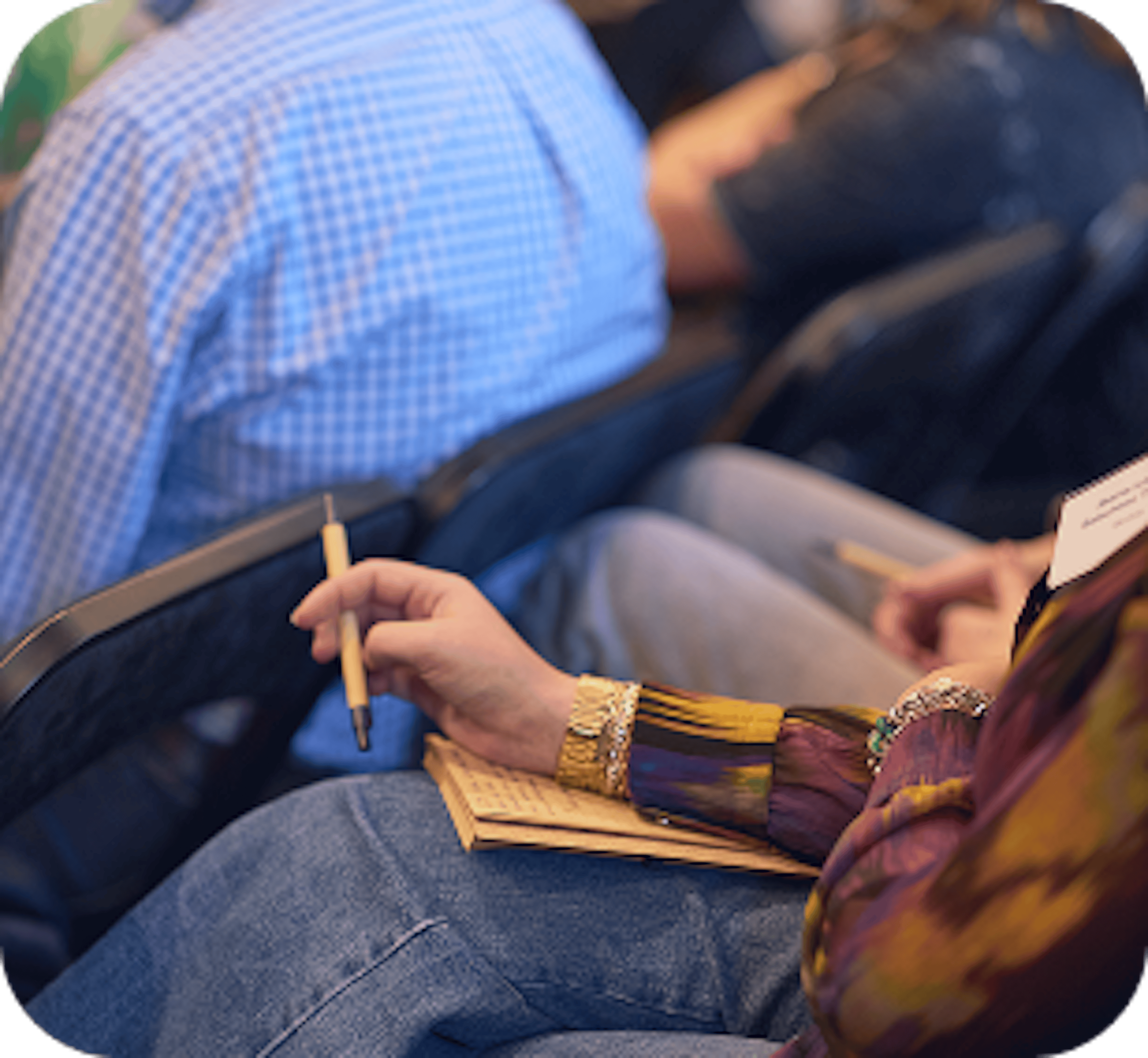 Participant prenant des notes assis dans un fauteuil lors d’un événement