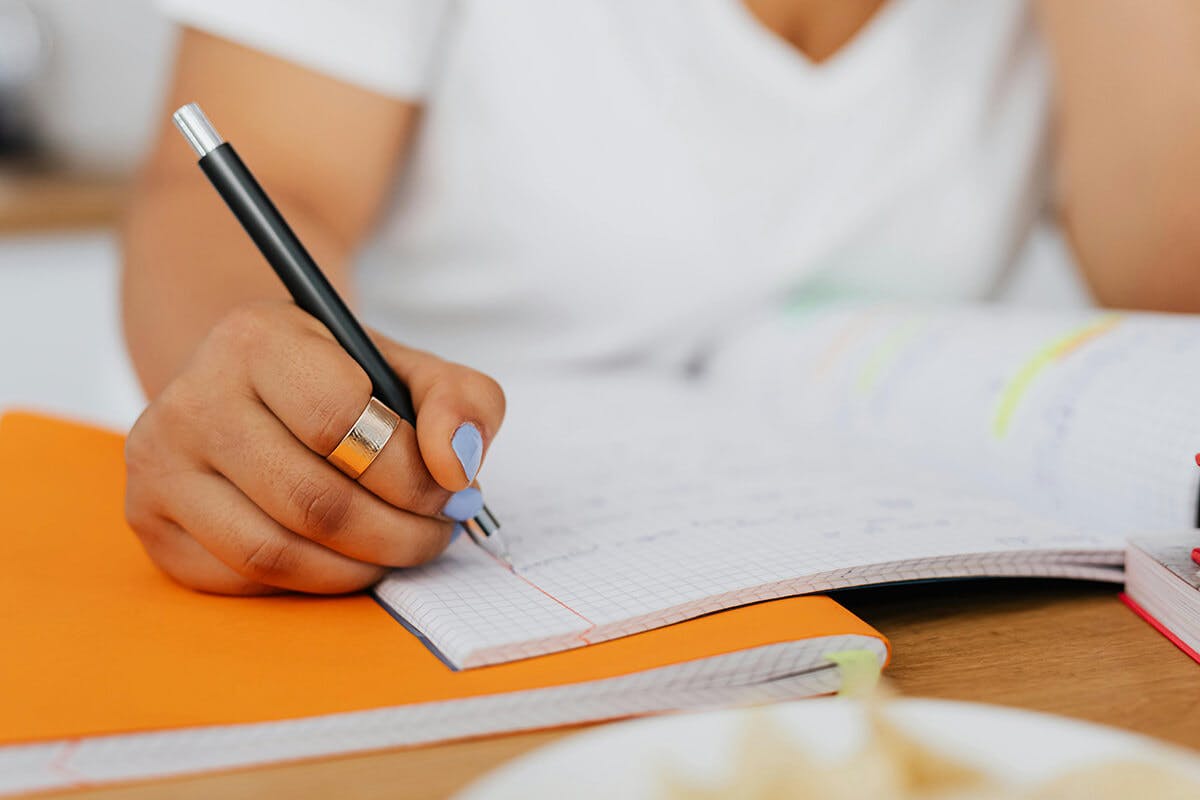 Une main qui écrit sur un carnet