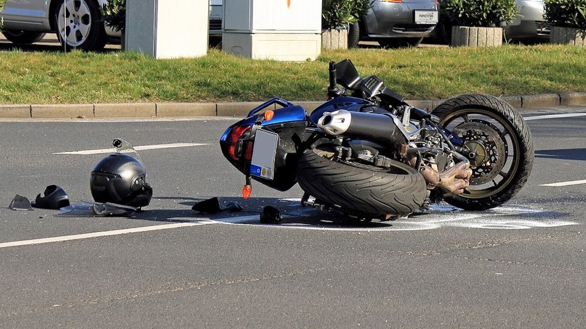 Moto bleue accidentee sur une route