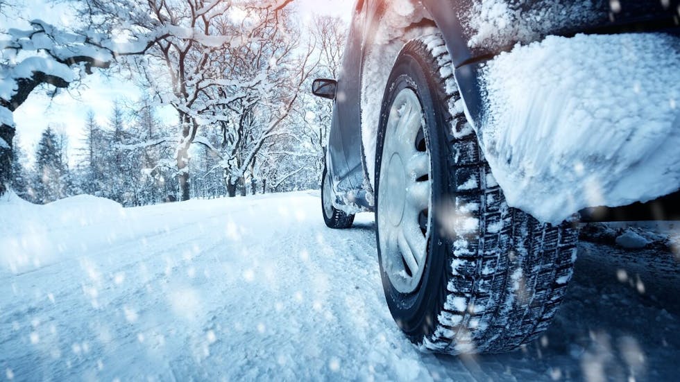 Une voiture équipée de pneus neige roulant sur la neige