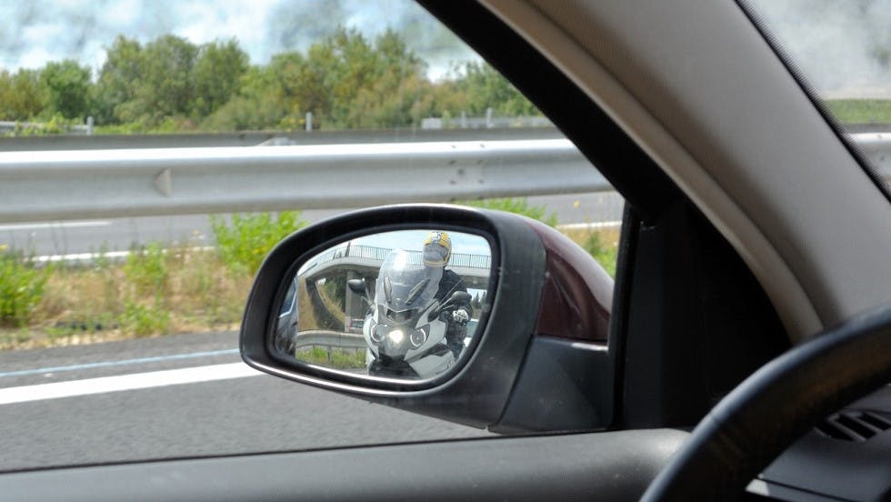 Deux roues motorise visible dans le retroviseur d'une automobile