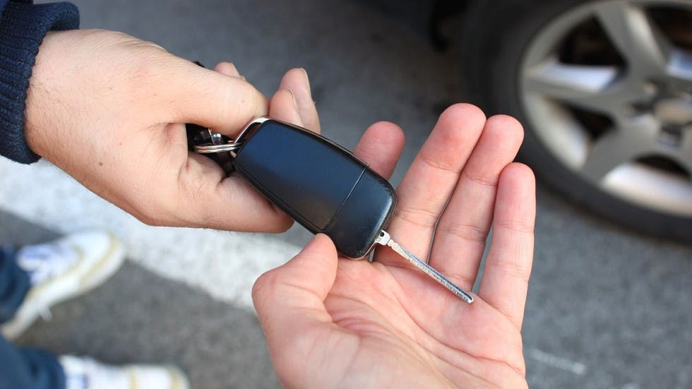 Automobiliste donnant les cles de son vehicule au nouveau proprietaire