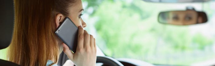 conductrice au téléphone devant son volant