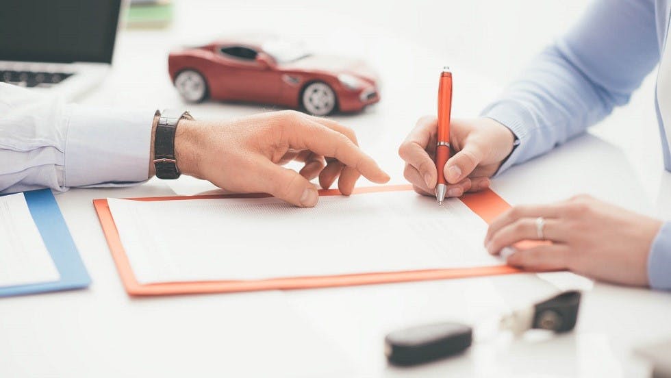 Usager signant le contrat de vente d'une automobile