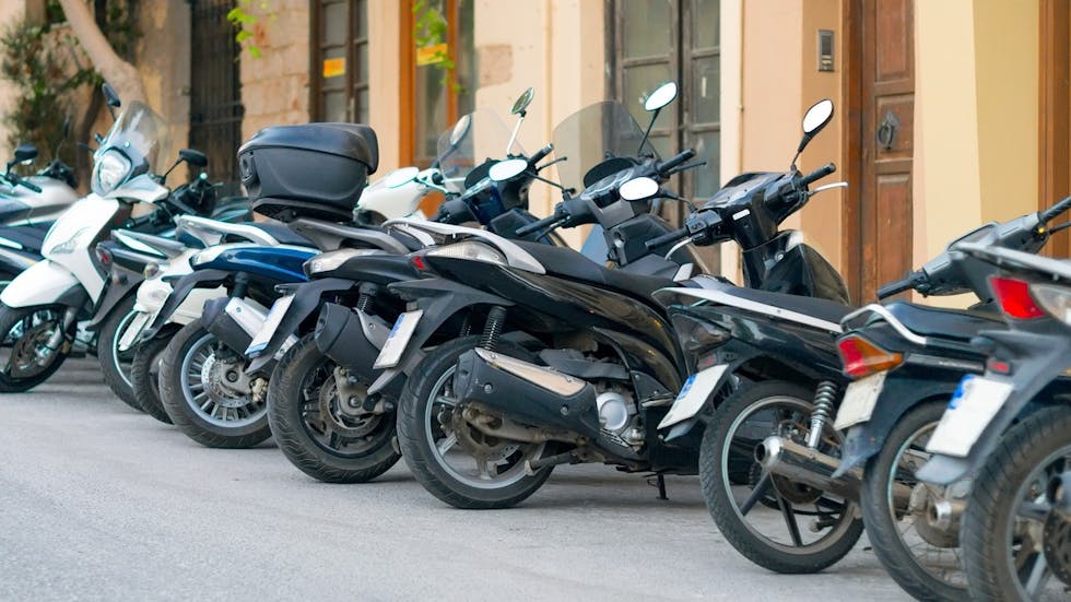 Photographie montrant des scooters garés sur un parking.