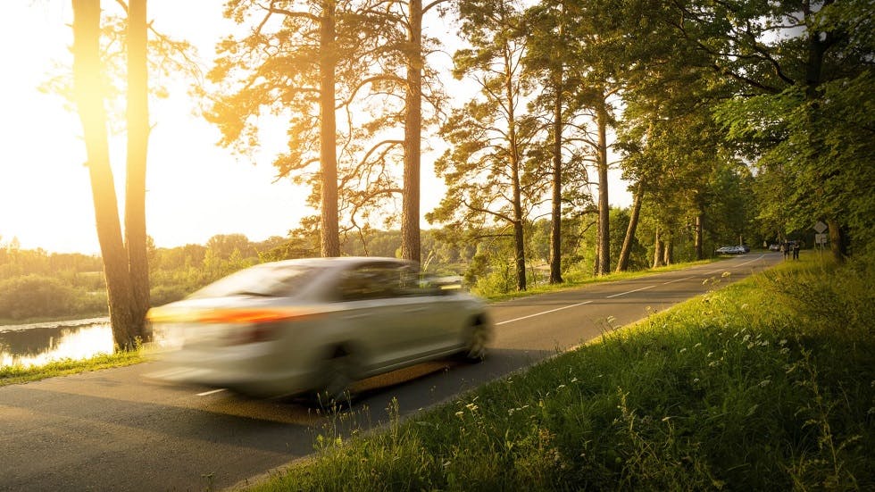 Automobile circulant rapidement sur une route de campagne