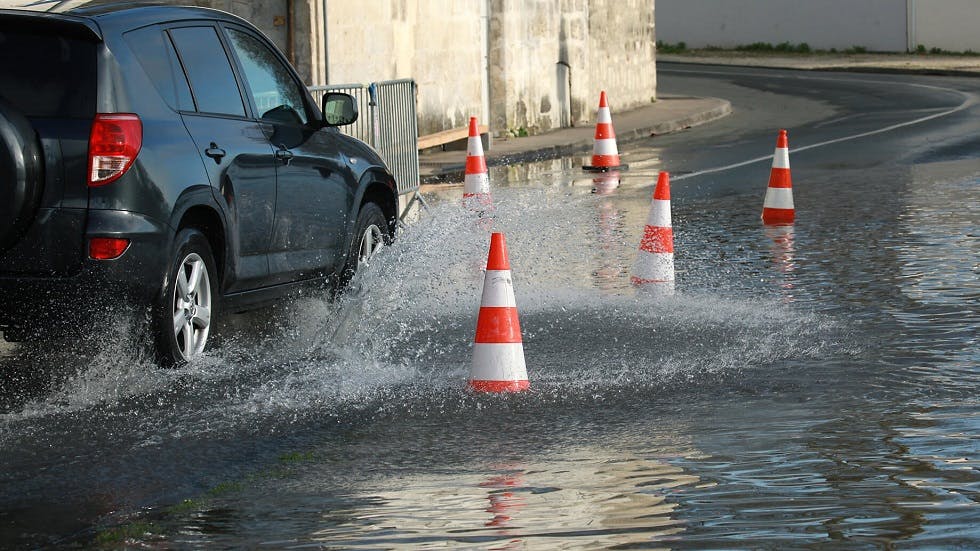 Automobile circulant le long d'une route inondée