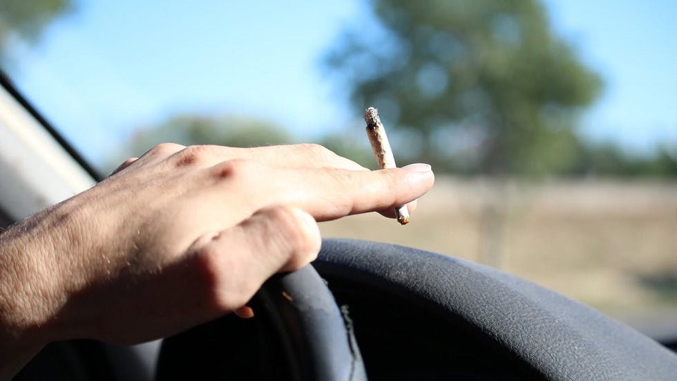 Automobiliste fumant une cigarette au volant
