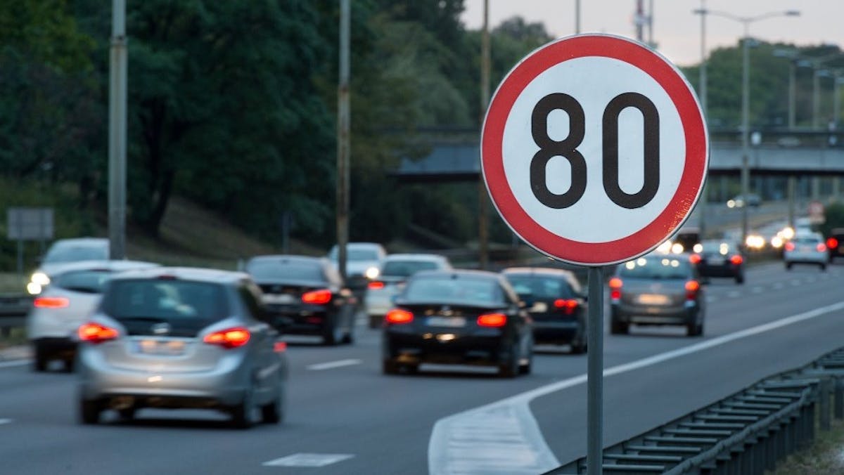 Vehicules ralentissant a hauteur d'un panneau indiquant 80 km/h