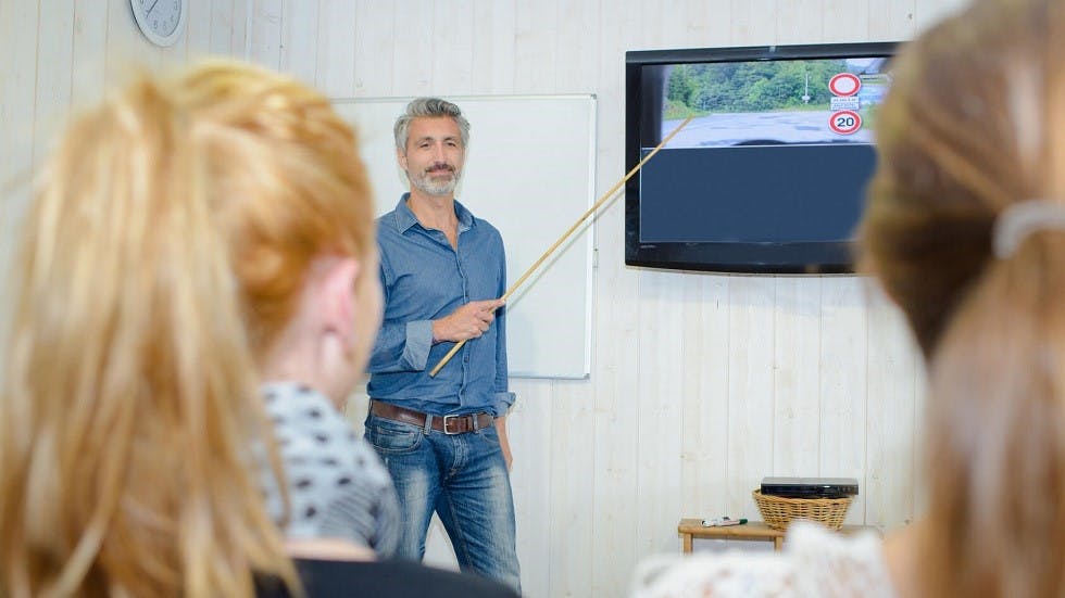 Instructeur presentant les reponses a des questions de l'examen du code de la route