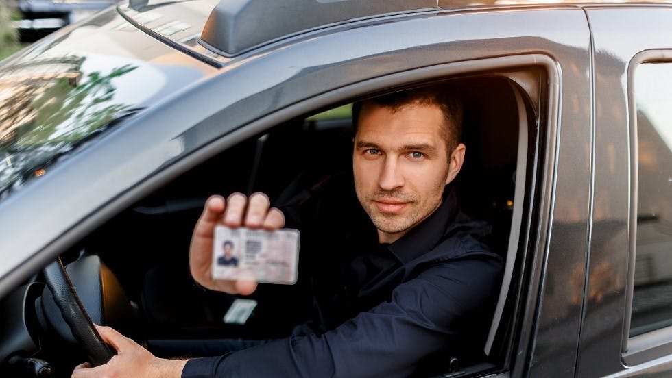 Automobiliste présentant son permis de conduire