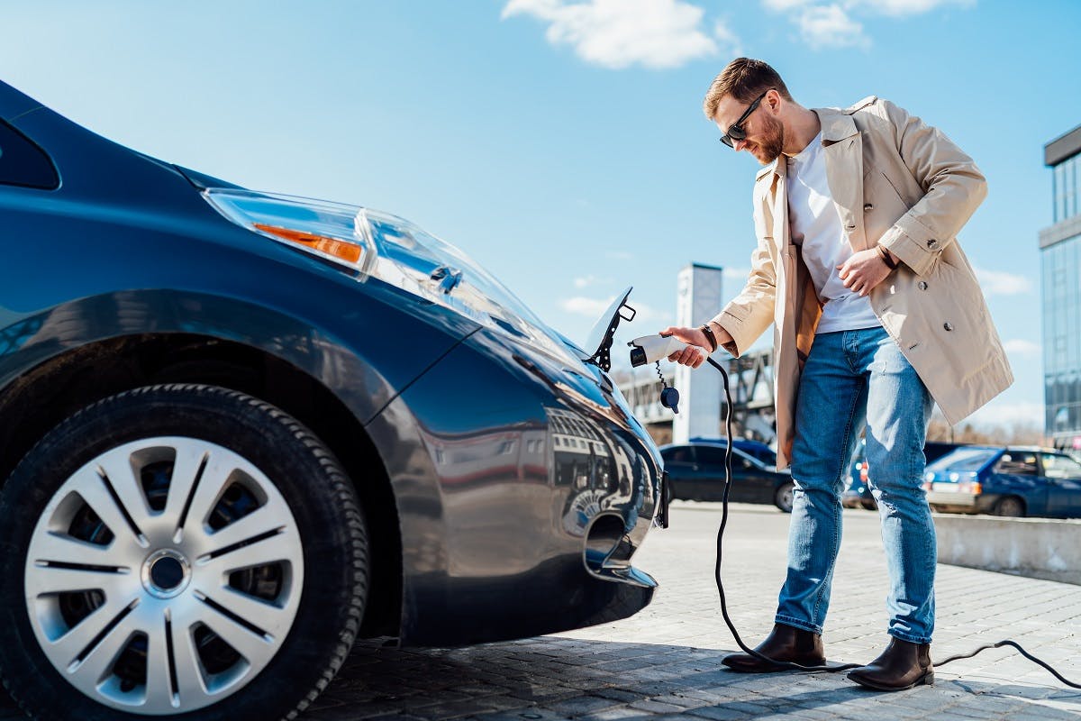 Conducteur de voiture electrique rechargeant son vehicule