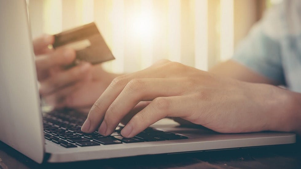 Homme entrant ses coordonnees bancaires sur un site internet