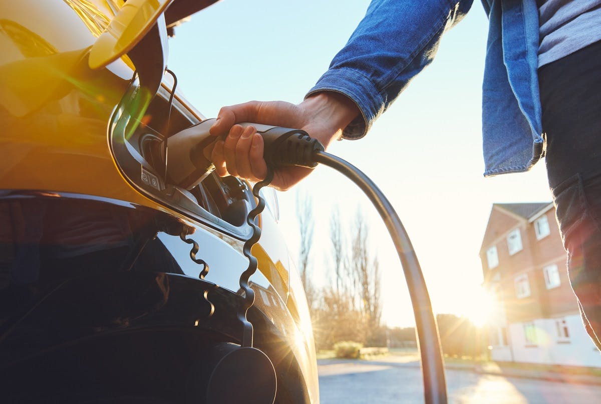 Automobiliste rechargeant une voiture electrique jaune