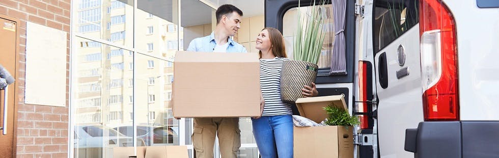 Couple en plein déménagement devant un utilitaire