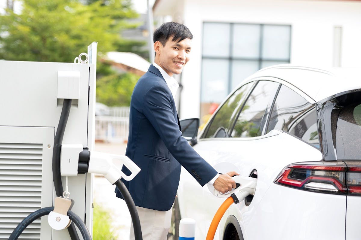 Usager rechargeant sa voiture sur une borne de recharge
