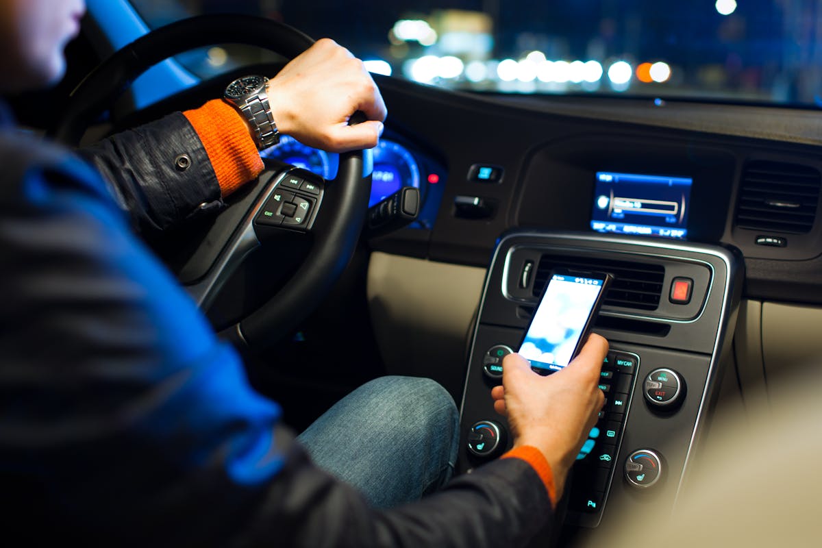 Conducteur avec son téléphone dans la main pendant qu'il conduit