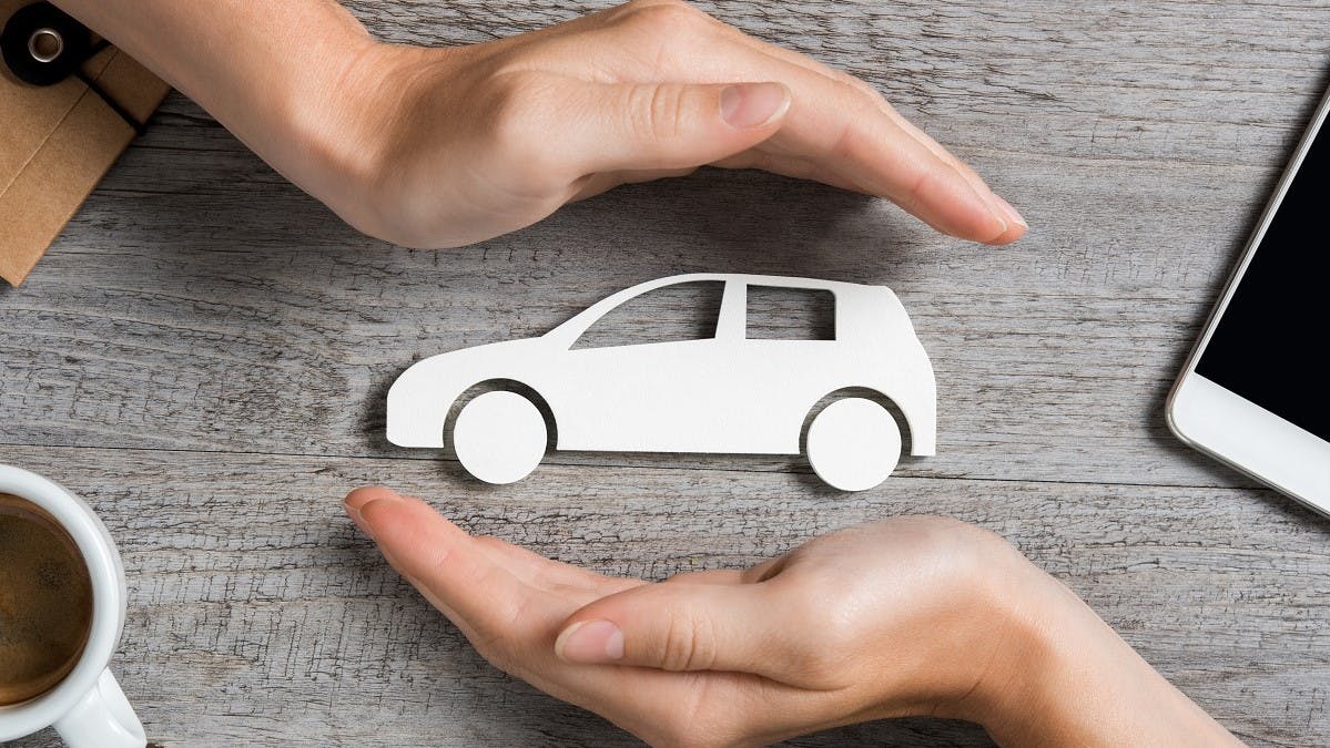 Mains protegeant symboliquement une voiture