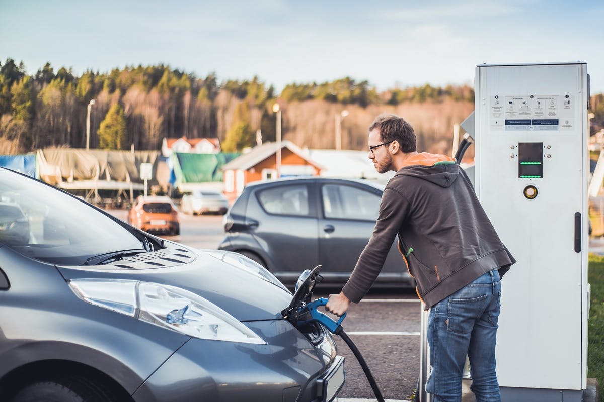 Automobiliste rechargeant sa voiture a une borne publique