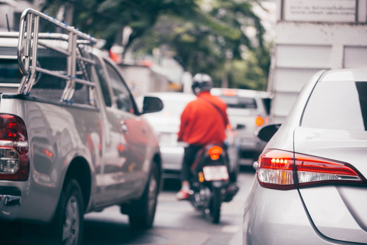 Scooter pratiquant de l'interfile dans une rue embouteillée